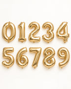 Champagne-gold foil number balloons from 0 to 9, arranged in two rows
