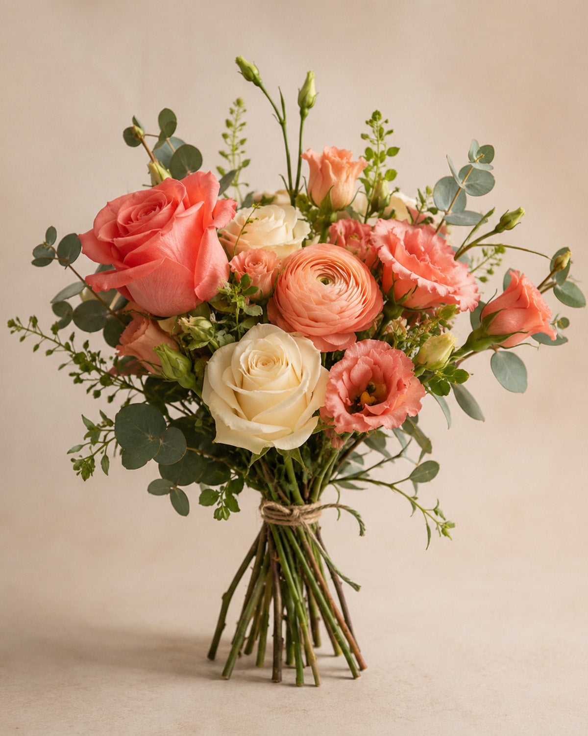 Coral and cream hand-tied bouquet with roses and greenery