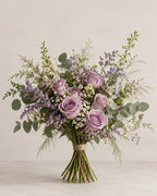 Lavender rose bouquet with purple filler flowers, eucalyptus and delicate white blooms