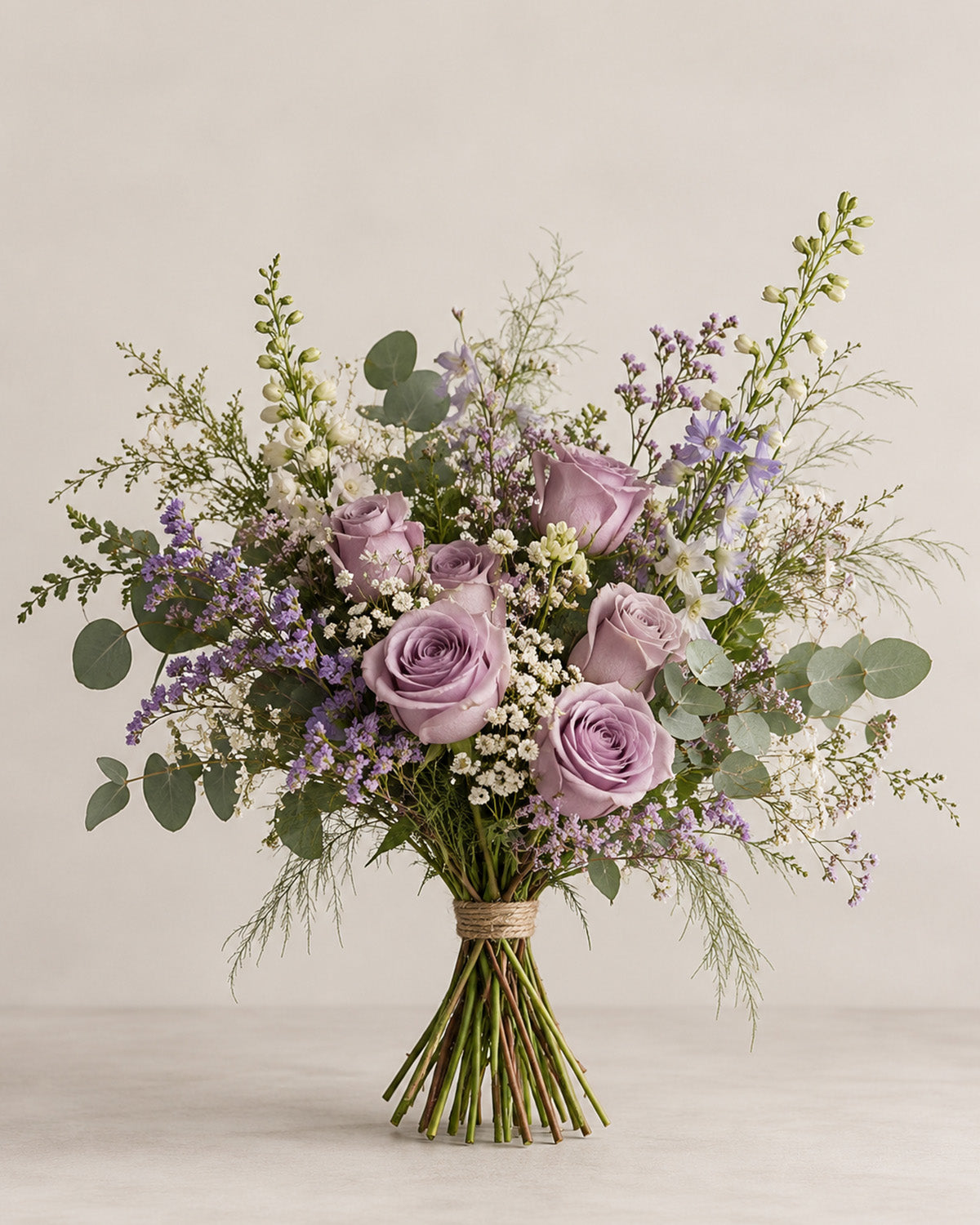 Lavender rose bouquet with purple filler flowers, eucalyptus and delicate white blooms