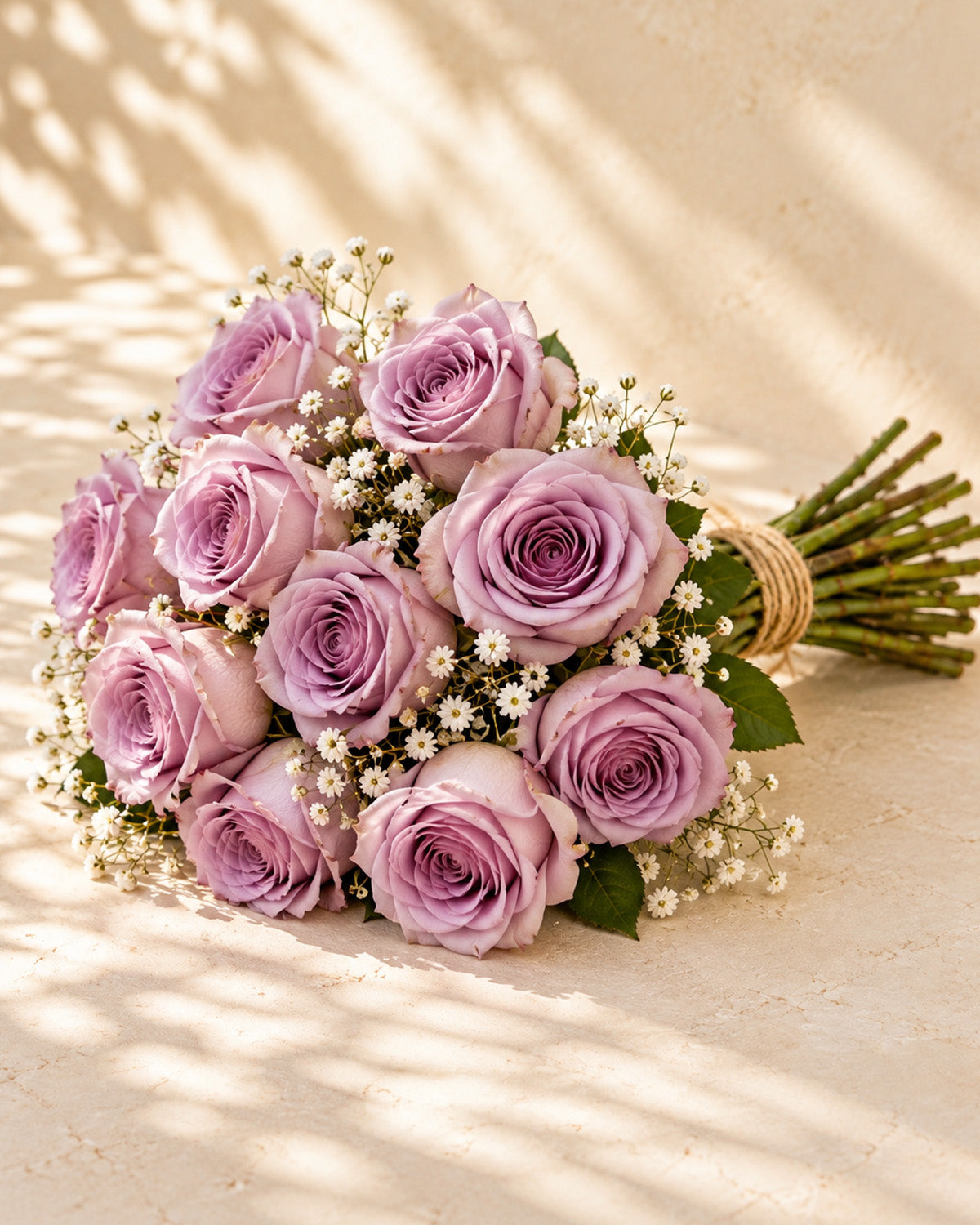 Lavender roses with baby's breath, greenery, and twine