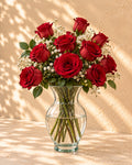 Red roses with baby's breath in a clear glass vase