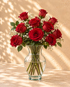 Red roses with baby's breath in a clear glass vase