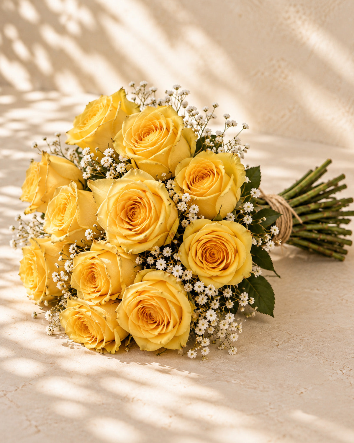 Yellow roses with baby's breath, greenery, and twine