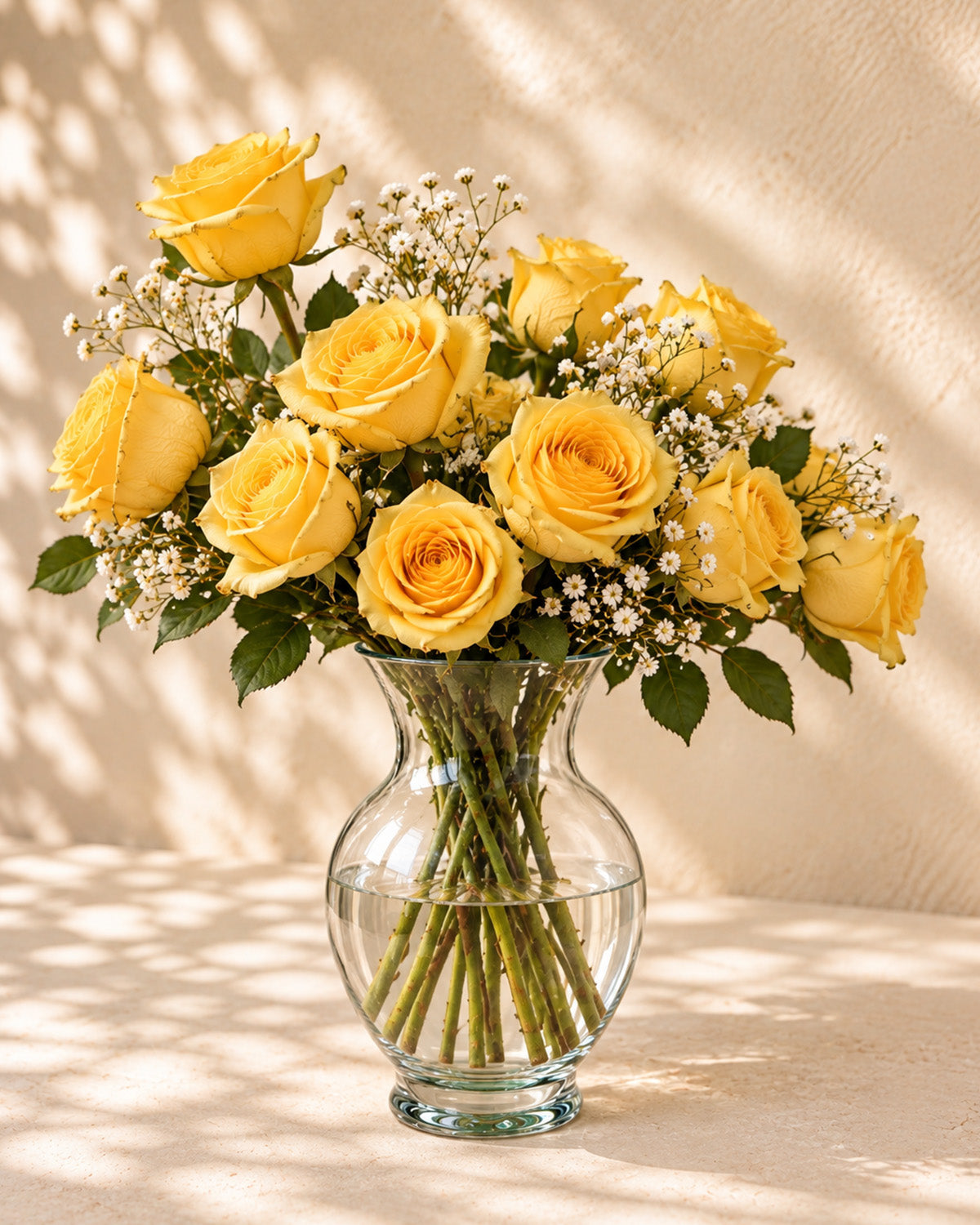 Yellow roses with baby's breath in a clear glass vase