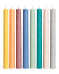Taper candles in yellow, peach, mauve, dusty blue, sage, teal, blush, and light gray